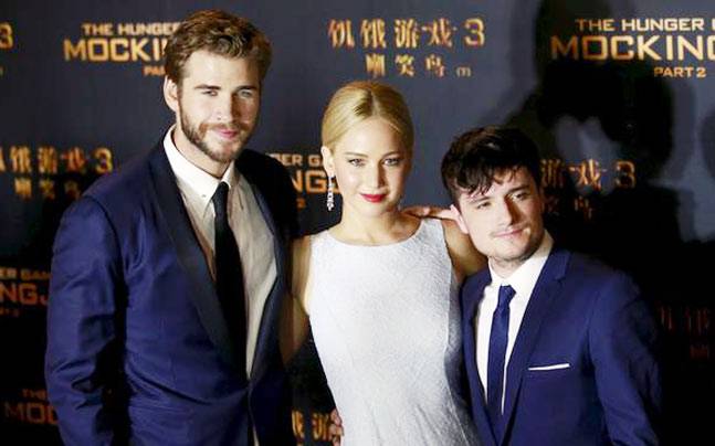 Cast members Liam Hemsworth Jennifer Lawrence and Josh Hutcherson pose at a red carpet event for the China premiere of The Hunger Games Mockingjay- Part 2 in Beijing China