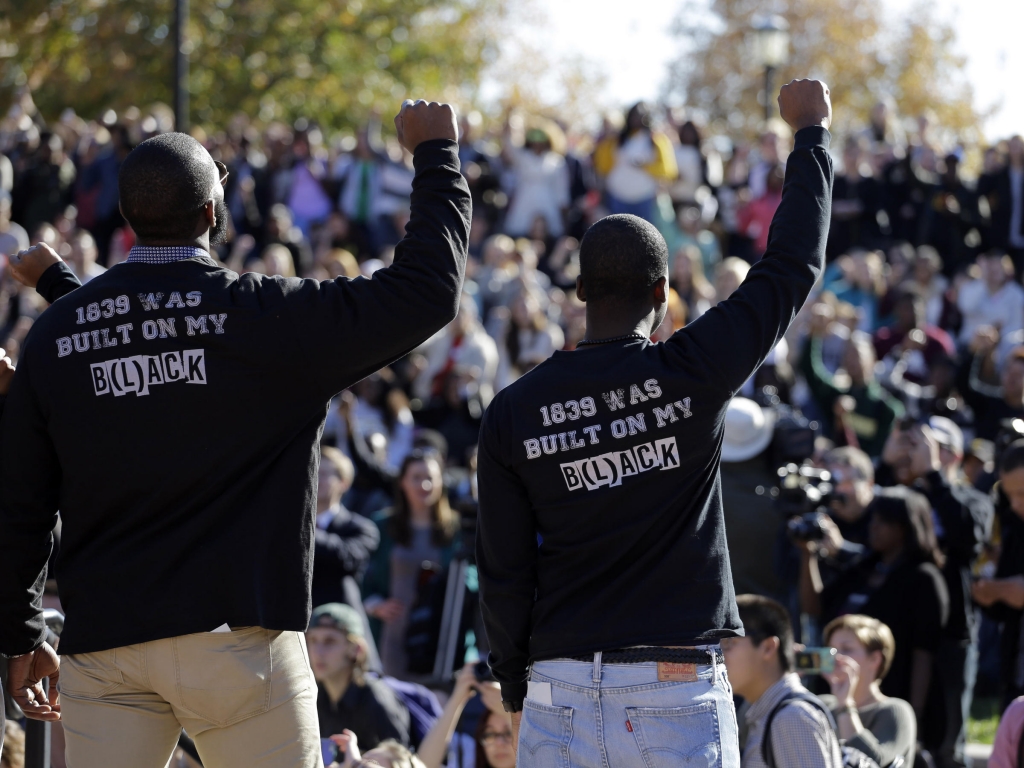 Members of the protest group Concerned Student 1950 raise their arms following the announcement University of Missouri System President Tim Wolfe would resign