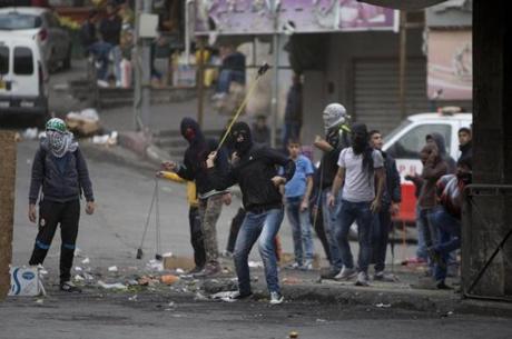 A Palestinian protester used a slingshot during clashes with Israeli soldiers in the West Bank city of Hebron on Thursday