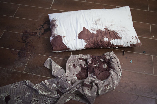 A blood stained pillow and pants lie on the floor next to bullet casings in a guest room of the Radisson Blu Hotel