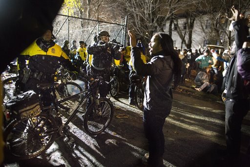 Jeremiah Ellison center right son of U.S. Rep. Keith Ellison stands near police during a protest at the Minneapolis Police Department 4th Precinct building in Minneapolis. People were protesting the fatal shootin