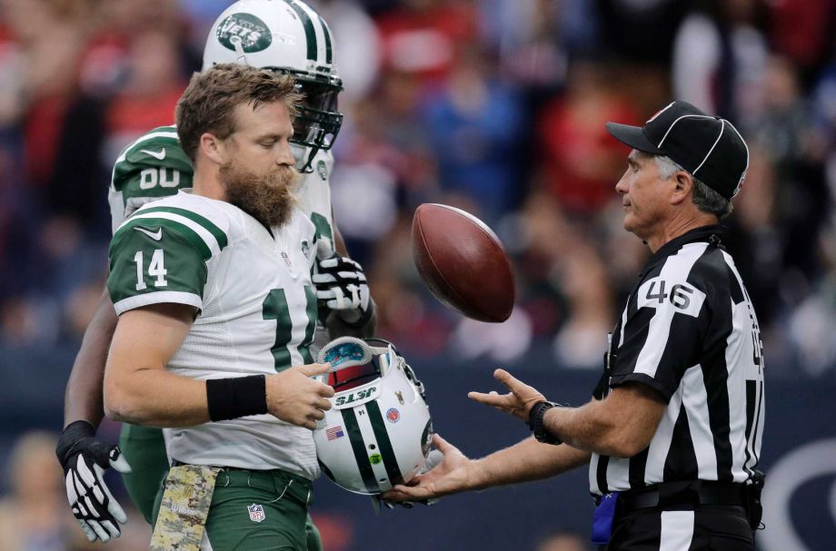 New York Jets quarterback Ryan Fitzpatrick trades official Perry Paganelli the ball for his helmet after he scored a touchdown against the Houston Texans during the second half of an NFL football game Sunday Nov. 22 2015 in Houston. Fitzpatr