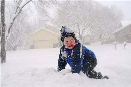 A young boy plays in the snow in Sioux Falls South Dakota. The first significant snowstorm of the season blanketed parts of the Midwest with more than a foot of snow