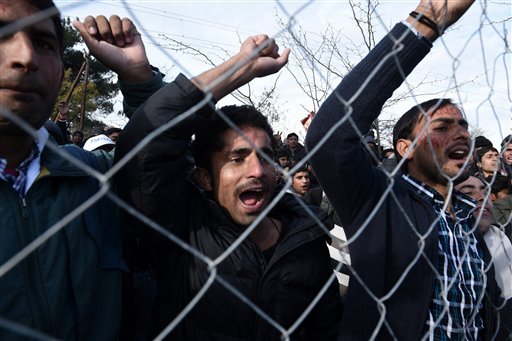 Pakistani migrants demonstrate behind a fence as they demand to be allowed to pass the Greek Macedonian border near the northern Greek village of Idomeni Thursday Nov. 26 2015. Migrants stranded at the border have been protesting for days as several