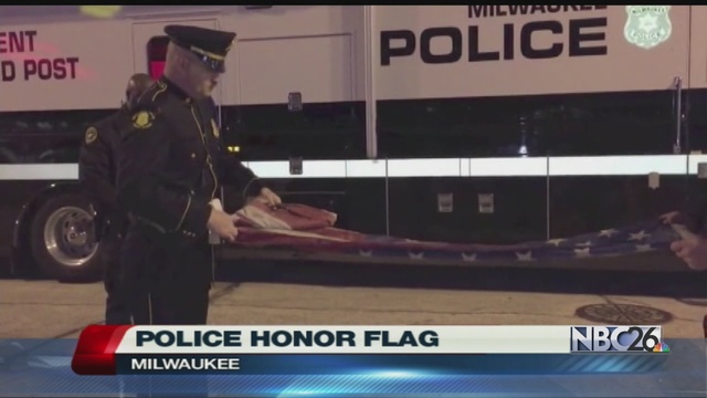 Milwaukee police ceremoniously fold an American flag that a protester desecrated outside the GOP debates on Tuesday.                      WGBA