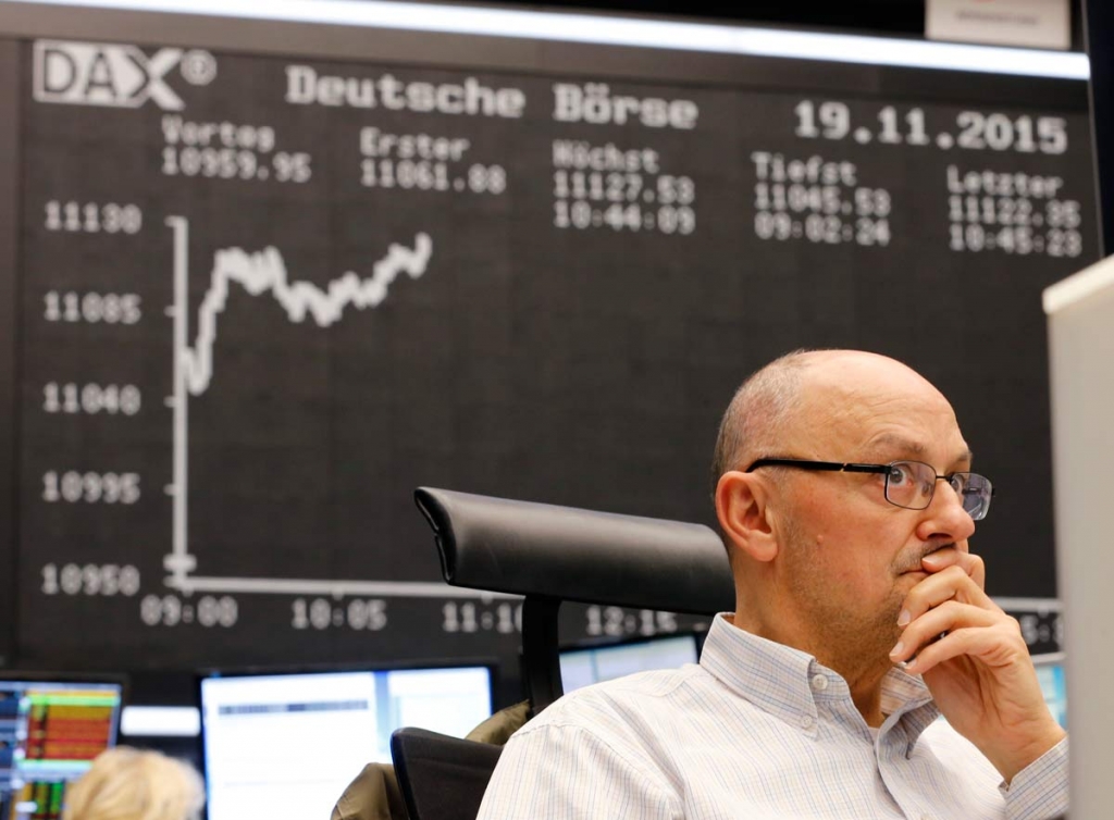 A trader watches his screens when the German stock index DAX went over 11 000 points at the stock market in Frankfurt Germany Thursday Nov. 19 2015