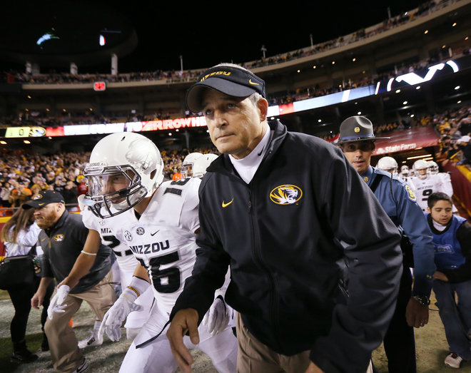 Missouri head coach Gary Pinkel second from right leads his players onto the field before an NCAA football game between Missouri and BYU on Saturday Nov. 14 2015 at Arrowhead Stadium in Independence Mo. Pinkel announced Friday he is stepping down