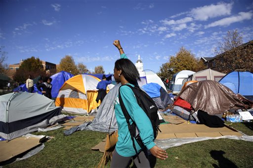 A woman passes a tent encampment set up by student protesters following an announcement that University of Missouri System President Tim Wolfe is resigning Monday Nov. 9 2015 at the university in Columbia Mo. Wolfe resigned Monday with the football