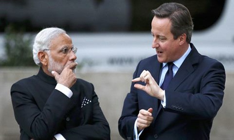 Britain's Prime Minister David Cameron right and India's Prime Minister Narendra Modi chat after paying homage at the statue of Mahatma Ghandi in Parliament Square in London Thursday Nov. 12 2015. Modi is on a 3 day visit to Britain. (Peter Nicholl