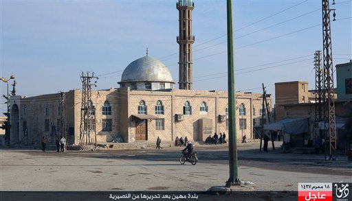 This image posted on Sunday Nov. 1 2015 by a website used by Islamic State militants shows Syrians in front of a mosque in the village of Mahin central Homs province Syria. The Islamic State militant group is advancing in central Syria seizing cont