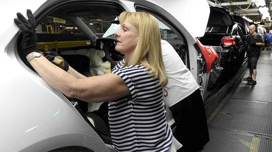 A worker installs a seal onto a 2015 Chevrolet Malibu at GM's Fairfax assembly plant in Kansas City Kansas