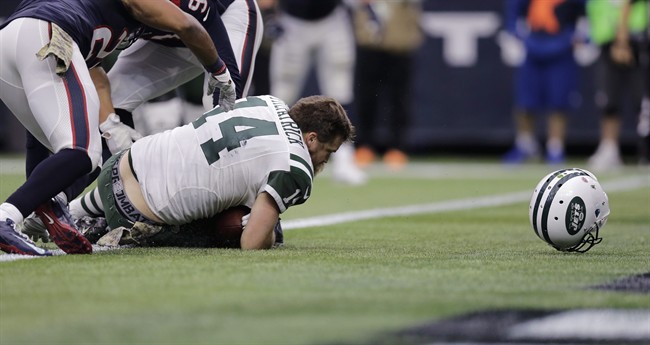 New York Jets quarterback Ryan Fitzpatrick loses his helmet as he scores a touchdown against the Houston Texans during the second half of an NFL football game Sunday Nov. 22 2015 in Houston