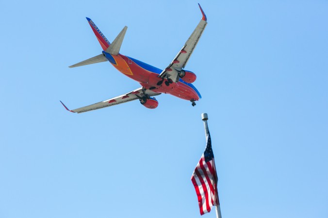 A Southwest Airlines jet flies over an American Flag before landing at the JFK airport in New York City