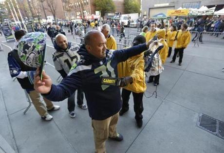 A guard used a metal detector to check a fan arriving for a Seattle Seahawks Arizona Cardinals game in Seattle on Sunday