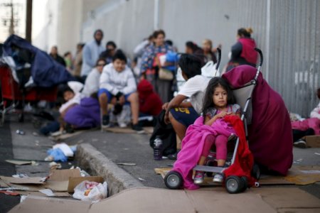 People wait in line at the Fred Jordan Mission annual back to school giveaway of shoes clothing and backpacks for more than 4,000 homeless and underprivileged children in Los Angeles California United States in this