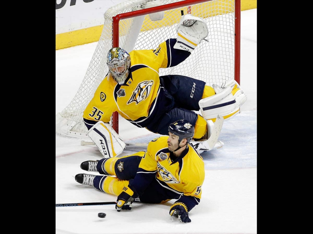 Nashville Predators defenseman Barret Jackman and goalie Pekka Rinne, of Finland dive to block a shot against the Anaheim Ducks in the third period of an NHL hockey game Tuesday Nov. 17 2015 in Nashville Tennessee