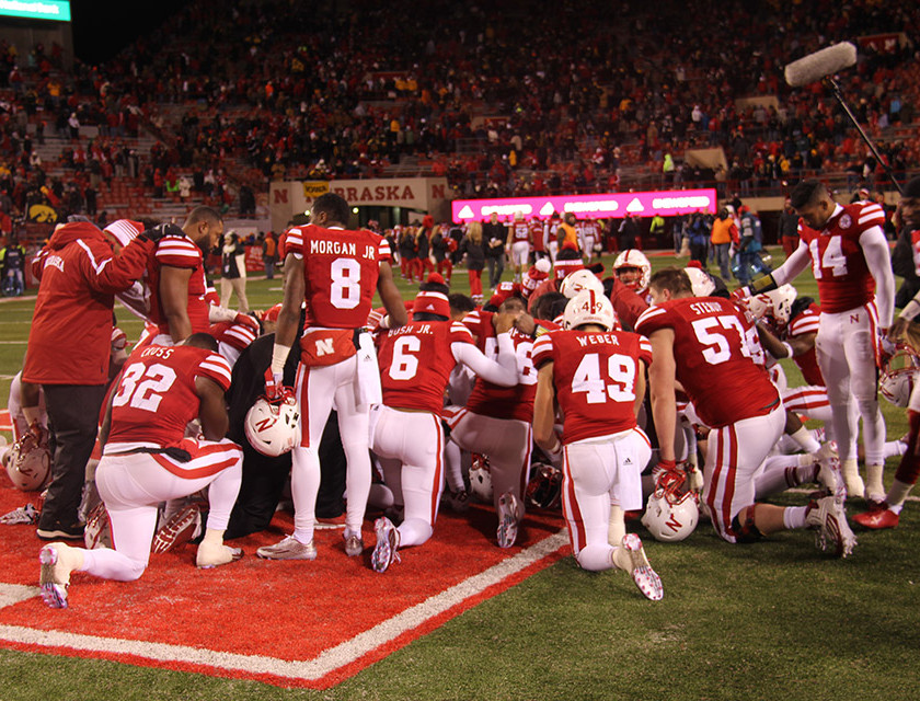 Nebraska players take a moment to gather around and say a prayer after a tough loss to Iowa