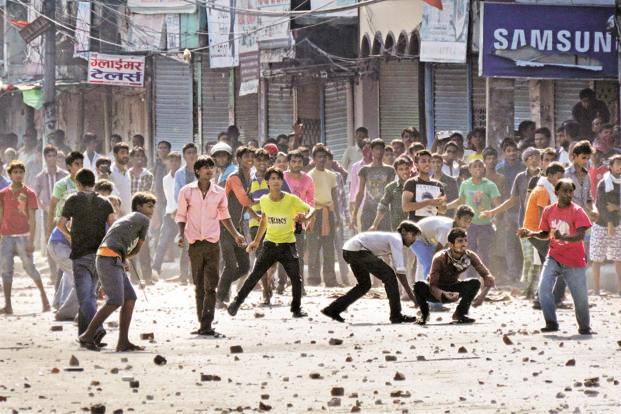 Nepalese protesters throw rocks at police during clashes near the Nepal India border at Birgunj on Monday