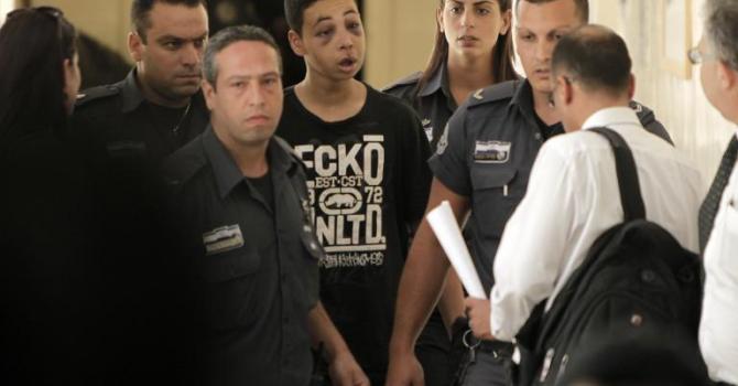 Le jeune américano-palestinien Tariq Abu Khdeir qui aurait été battu lors de son arrestation par la police arrive escorté de policiers israéliens à une audience judiciaire au tribunal de Jérusalem le 6 juillet 2014