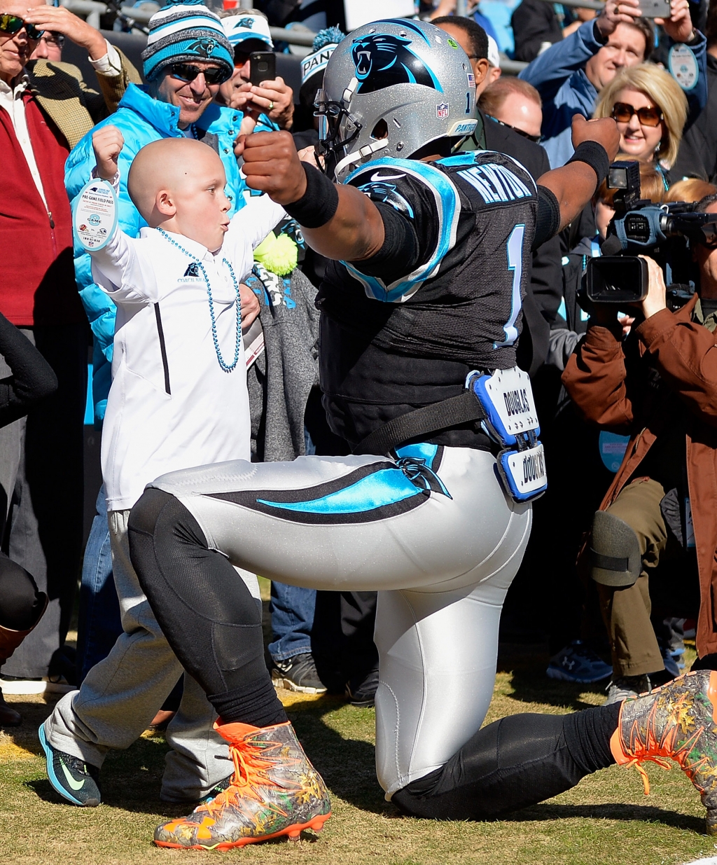 Newton greets a young cancer patient before Sunday’s game