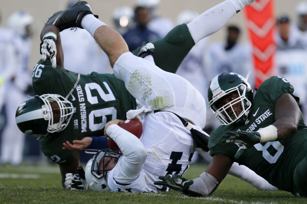 Penn St Michigan St Football Penn State quarterback Christian Hackenberg center is sacked by Michigan State's Joel Heath left and Lawrence Thomas right during the second quarter in East Lansing Mich