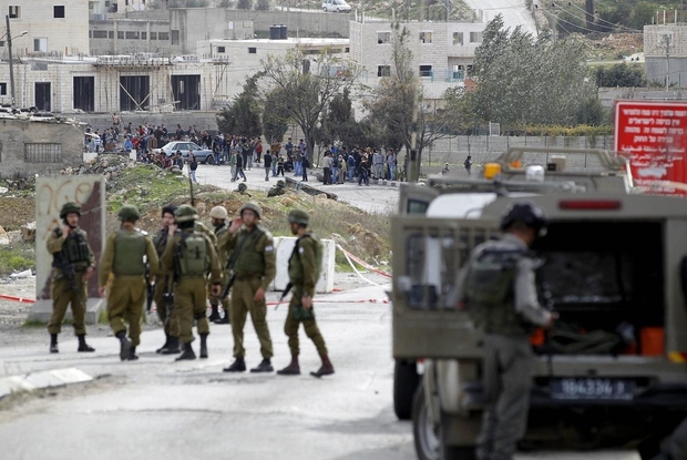 Israeli soldiers clear a road after a Palestinian woman was shoot dead after she drew a knife in check point near the West Bank Palestinian town of Qalqilya Monday Nov. 9 2015. Defense Ministry spokeswoman Arielle Heffez says the woman ignored warning