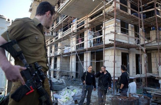 Israeli policemen search for a Palestinian man who is suspected of stabbing and wounding a woman in north Jerusalem earlier in the day in a neighborhood in the centre of Jerusalem