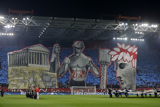 Olympiakos fans hold up a giant banner depicting landmarks of the city before the Champions League Group F soccer match between Olympiakos and Dinamo Zagreb at the Georgios Karaiskakis stadium in Piraeus port near Athens Wednesday Nov. 4 2015. (AP Pho