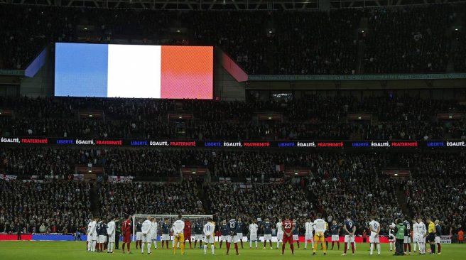 England and France squad members observe a minute's silence before the start of the friendly football match between England and France at Wembley Stadium in west London