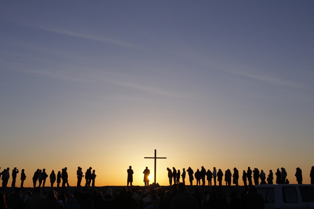 People are silhouetted as the sun rises during an Easter sunrise service in Scituate Massachusetts