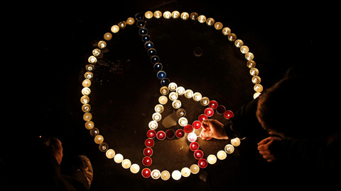 People light candles at the Place de la Republique in Paris