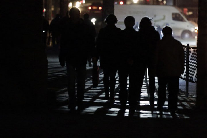 People walk along a street during a power outage in the Crimean city of Simferopol