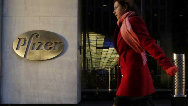 A woman passes Pfizer's current world headquarters in New York. Pfizer and Allergan will join in a $US160 billion deal to create the world's largest drugmaker