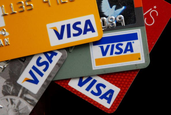 Visa credit cards are arranged on a desk