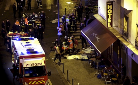 Rescue service personnel working near covered bodies outside a restaurant following shooting incidents in Paris on Nov. 13