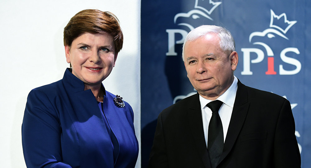 Jaroslaw Kaczynski, the leader of the conservative Law and Justice party shakes hands with designated prime minister Beata Szydlo after she announced members of her new cabinet