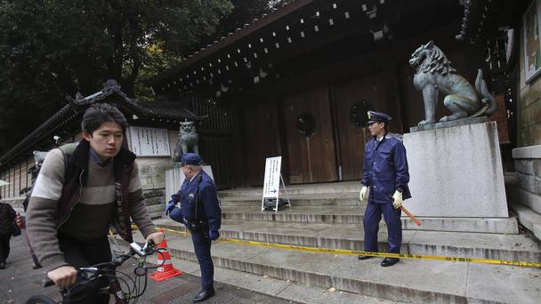 Police officers stand guard outside the south gate of Yasukuni shrine in Tokyo