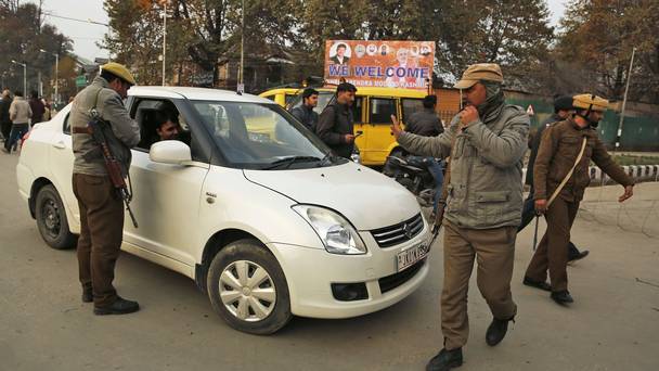 Policemen stop civilians near the venue of Narendra Modi's rally in Srinagar