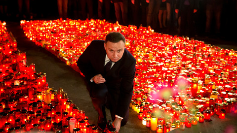 Polish President Andrzej Duda places a candle outside the Colectiv nightclub in Bucharest Romania