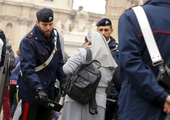 Italian Carabinieri officers check a nun as she arrives to attend Pope Francis Wednesday general audience in Saint Peter's square at the Vatican