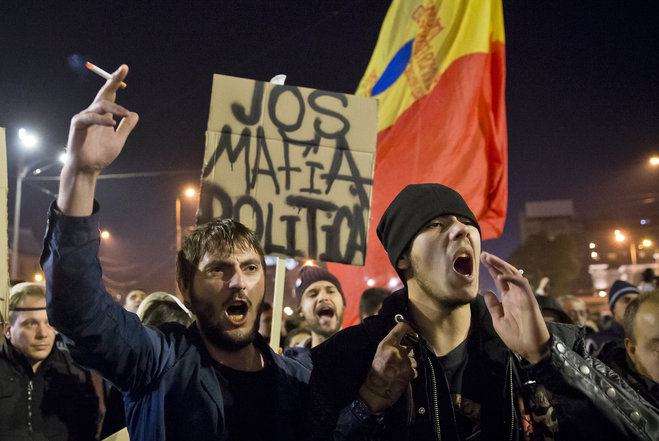 Protesters shout slogans calling for early elections and hold banners that read'Down the Political Mafia after a rally joined by thousands blocked traffic in University Square in Bucharest Romania Wednesday Nov. 4 2015. Prime Minister Victor Ponta