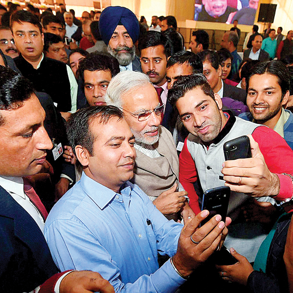 Prime Minister Narendra Modi poses for a selfie with reporters during ‘Diwali Mangal Milan’ at the BJP headquarters in New Delhi on Saturday 
    
    PTI