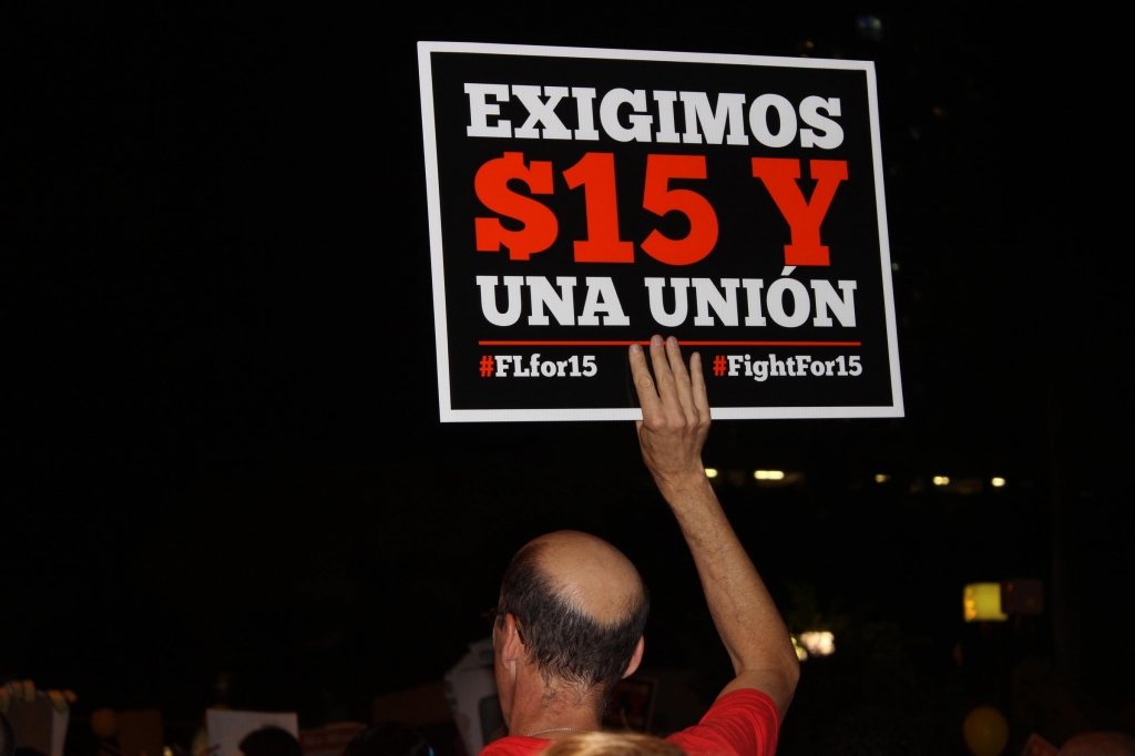 Protester holding up a sign that reads'We demand $15 and a union