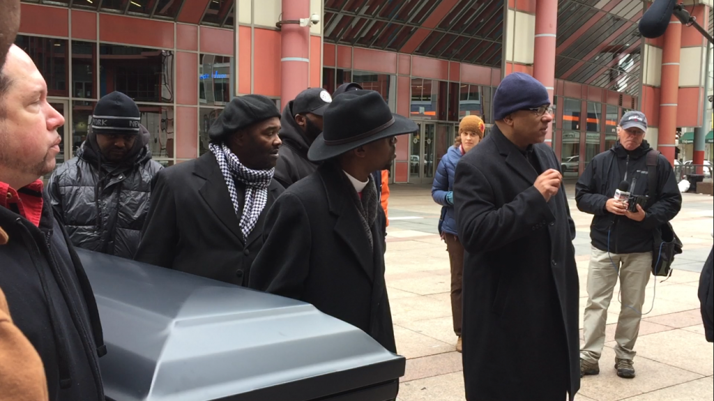 Protesters carry a coffin to City Hall on Saturday