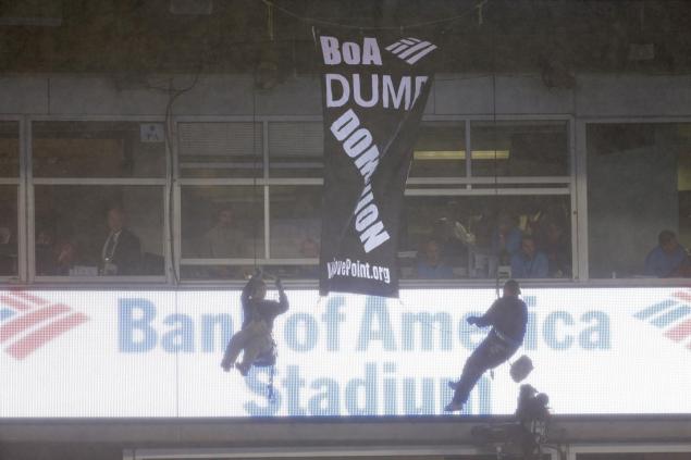 People hang from a banner they unfurled from the upper deck at Bank of America stadium in the second half of an NFL football game between the Carolina Panthers and the Indianapolis Colts