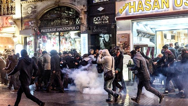 Protesters run for cover from tear gas fired by Turkish riot police during a demonstration in Istanbul after a top Kurdish lawyer was killed in Diyarbakir