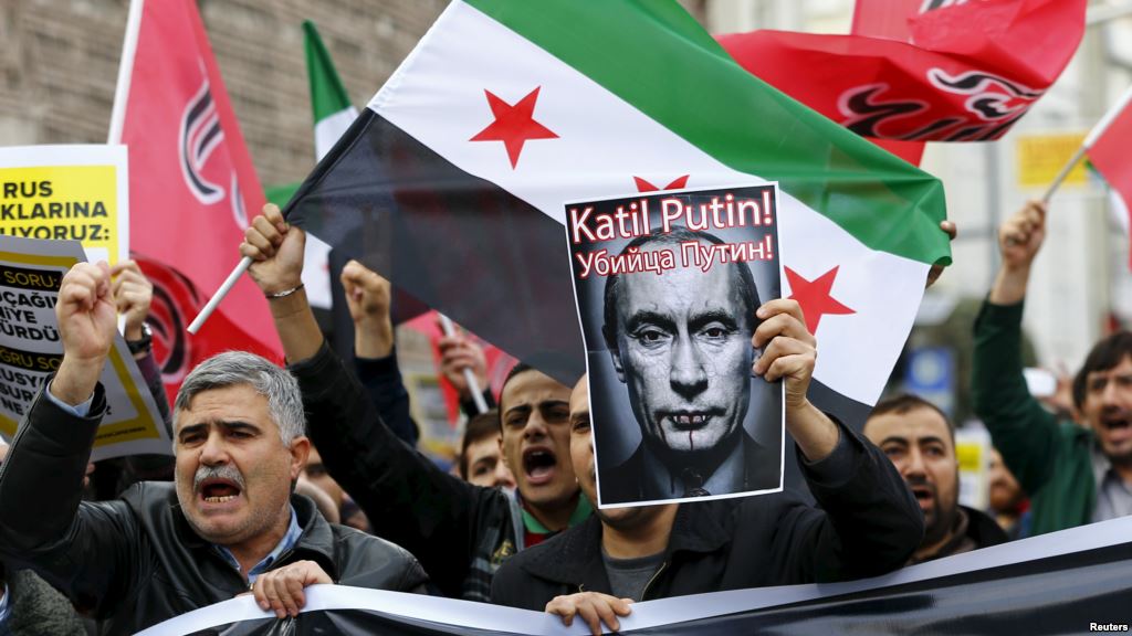 Pro-Islamist demonstrators holding a Syrian opposition flag and a defaced poster of Russian President Vladimir Putin shout slogans during an anti Russian protest in Istanbul Turkey on November 27