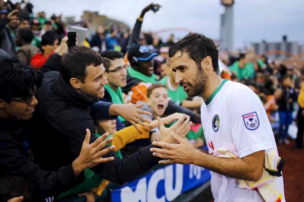 New York Cosmos player Raul Gonzalez shakes hands with fans while he exits the field after winning Fort Lauderdale Strikers during their soccer match in NASL Championship Semifinals in Brooklyn New York