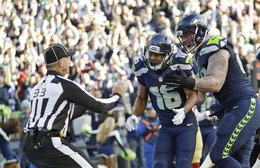 Seattle Seahawks wide receiver Tyler Lockett and offensive guard Justin Britt right celebrate in front of back judge Scott Helverson left after Lockett scored a touchdown against the San Francisco 49ers in an NFL football game Sunday Nov. 22 20