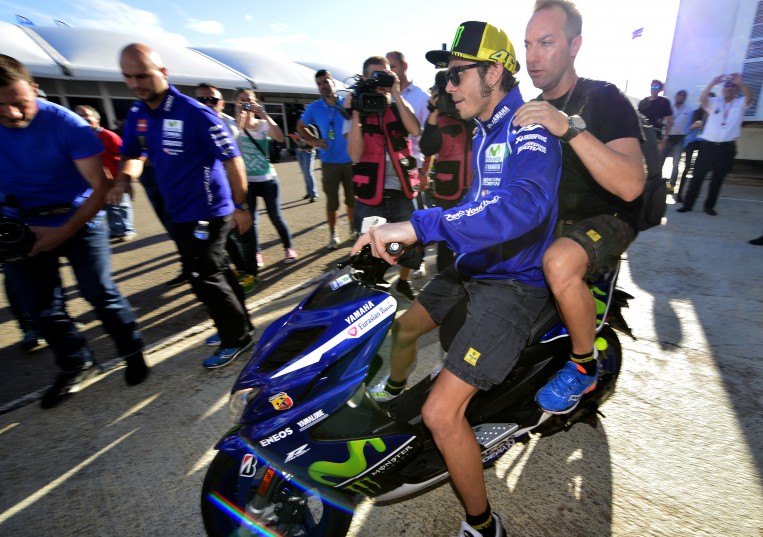 Movistar Yamaha's Italian rider Valentino Rossi crosses the paddock on a scooter prior to a meeting on the first day of the Valencia Grand Prix at Ricardo Tormo racetrack in Cheste near Valencia